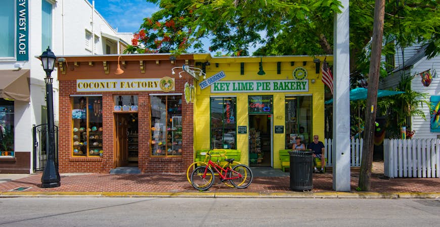 Tourists on relax on a summer day on the streets of Key West, Florida with colorful storefronts.