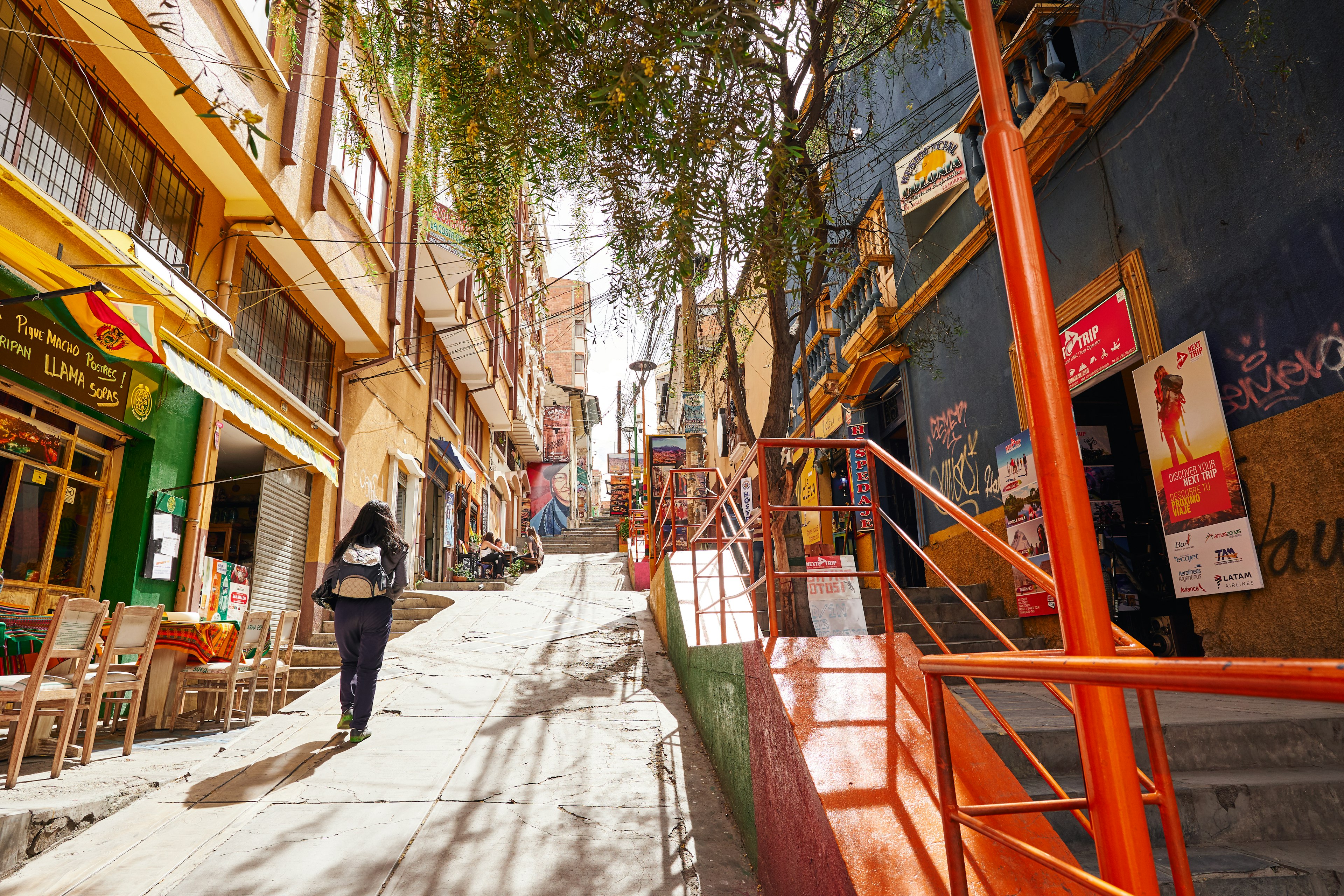 A steep street lined with shops and restaurants in Tarija, Bolivia