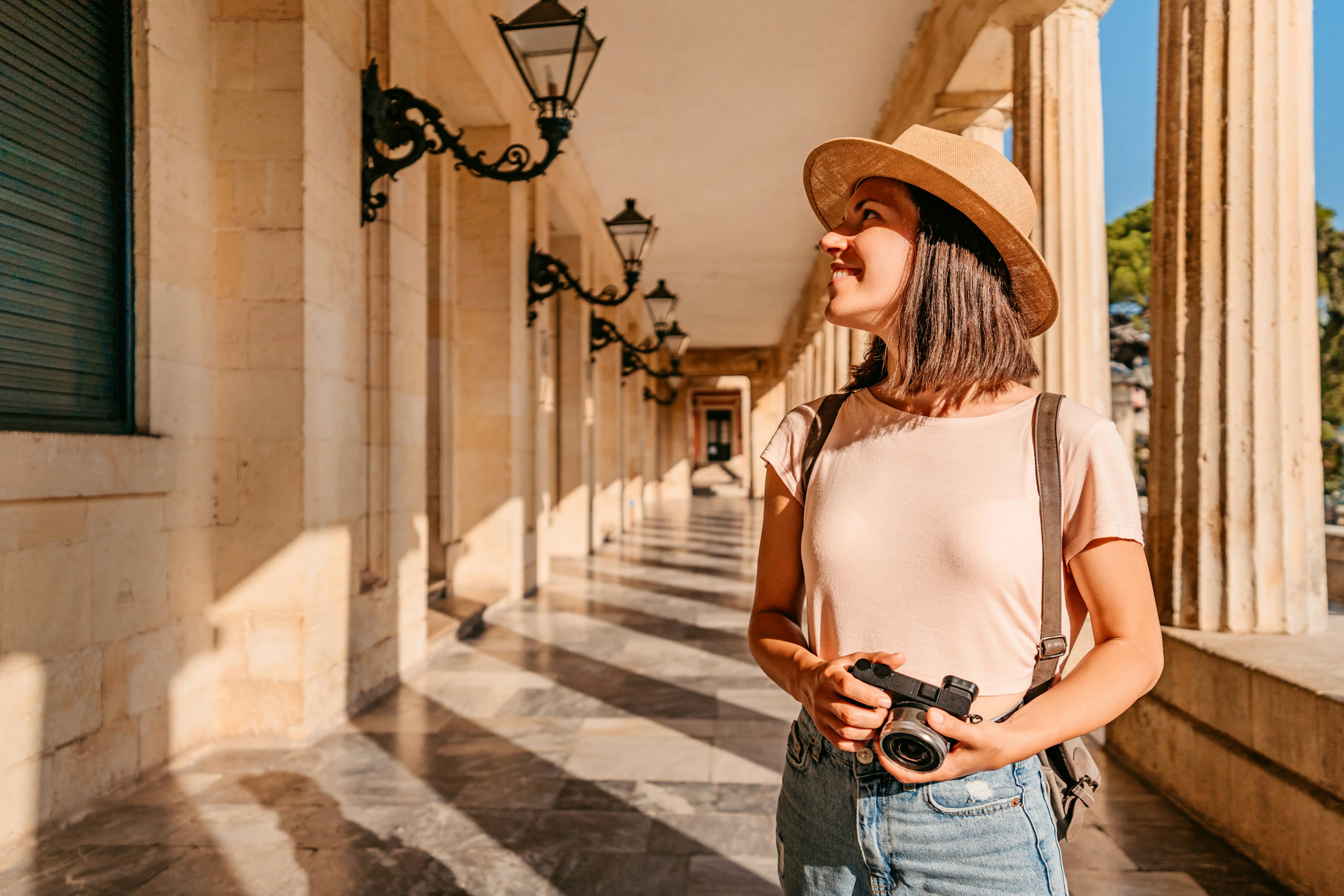 Woman with a camera admire the architecture of Corfu Town, Greece