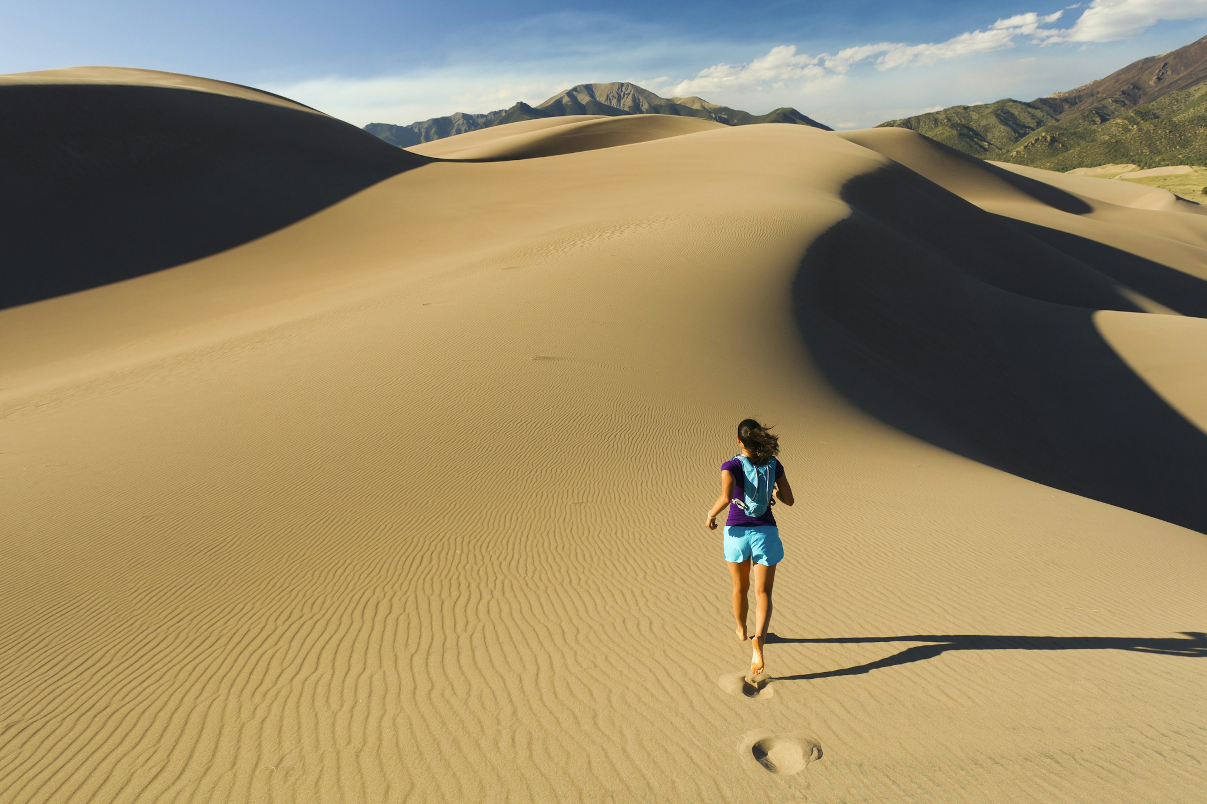 Woman running on sand dune in Great Sand Dunes National Park, Colorado