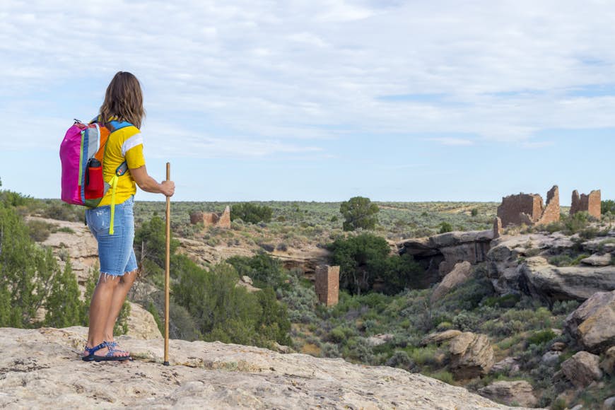 En vandrare gör en paus för att se indianruinerna vid Hovenweep National Monument i Colorado