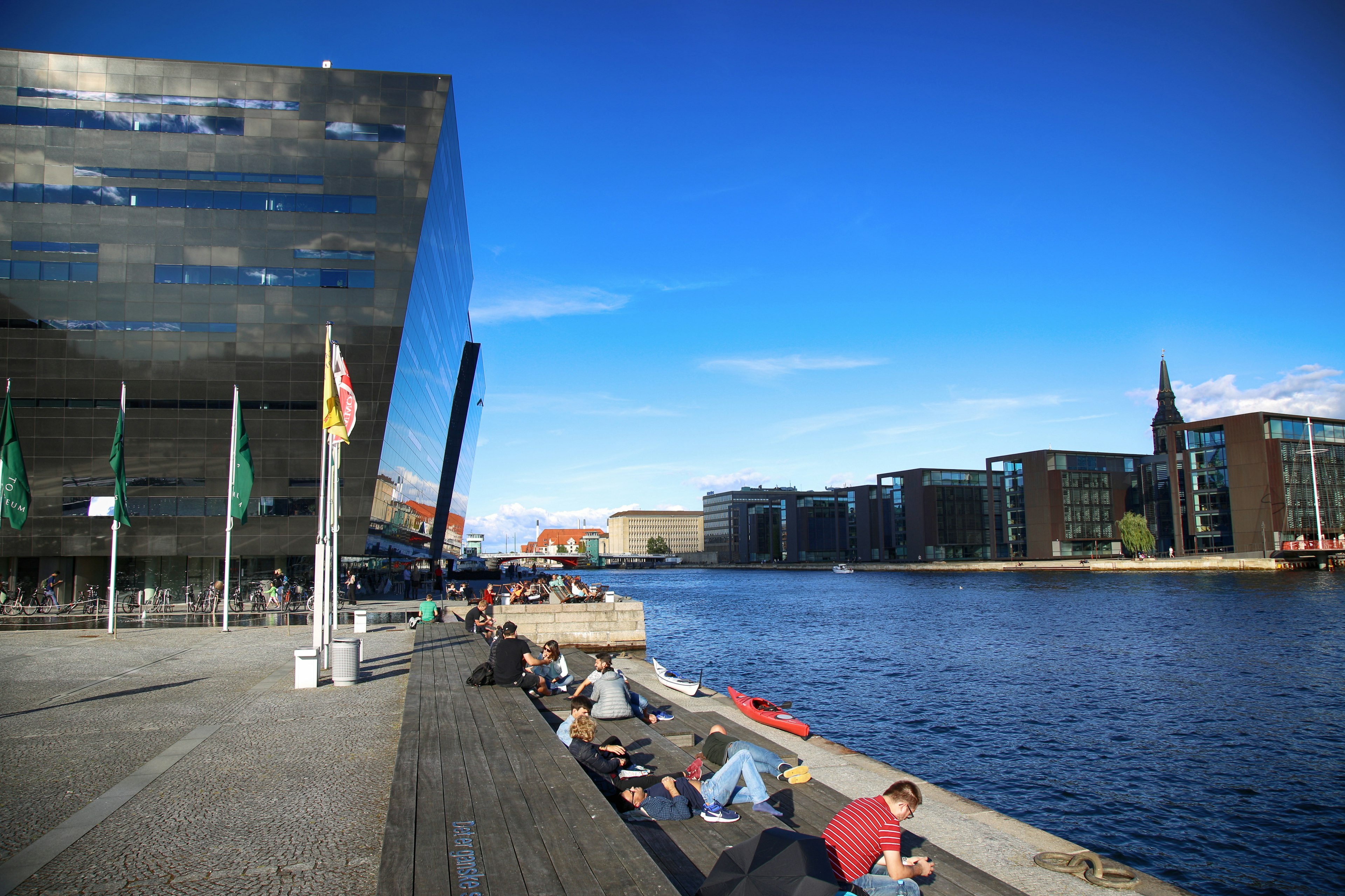 People relax by the Black Diamond, the national library of Denmark