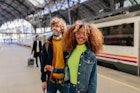 Young multi-ethnic couple waiting for train on platform at train station in Spain