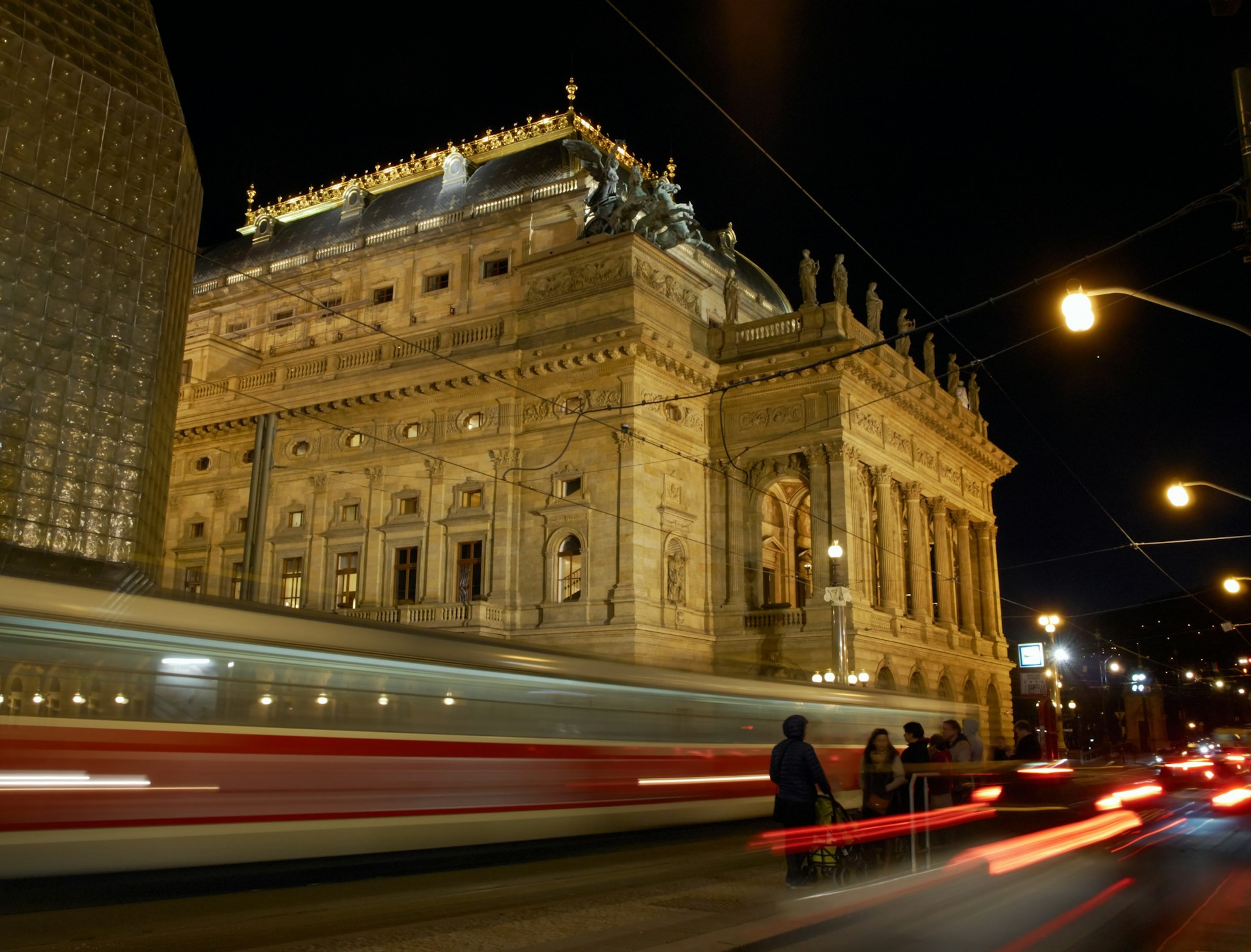 Night view on the National Theatre in Prague from the National Avenue. The old tram leaving the station.