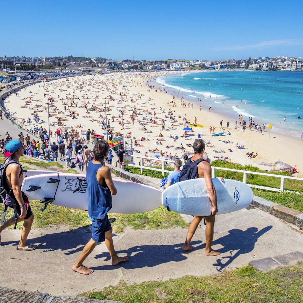 Sydney, Australia - November 19, 2015: Three surfers heading to the Bondi Beach Bondi beach with their surf boards on a sunny day.