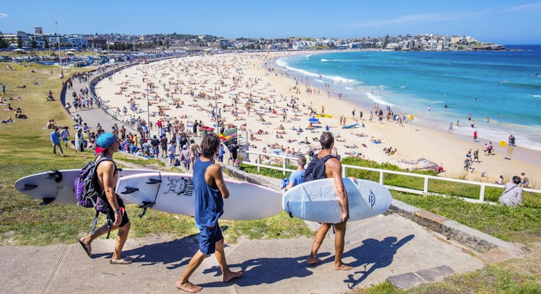Sydney, Australia - November 19, 2015: Three surfers heading to the Bondi Beach Bondi beach with their surf boards on a sunny day.