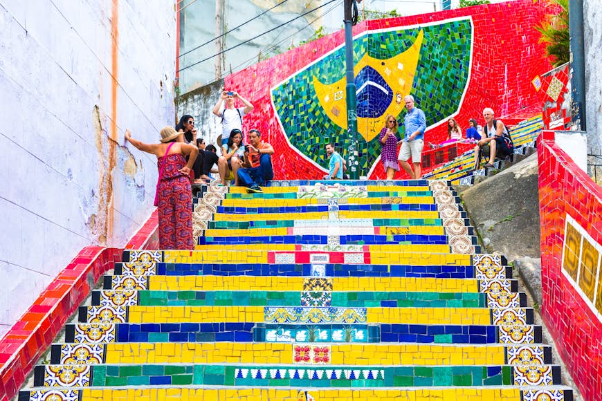 Tourists visiting the brightly painted Selaron stairway in Rio de Janeiro, Brazil. The stairway is the work of Chilean artist Jorge Selaron.