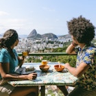 Couple on holiday in Rio de Janeiro, sitting at table, enjoying breakfast al fresco