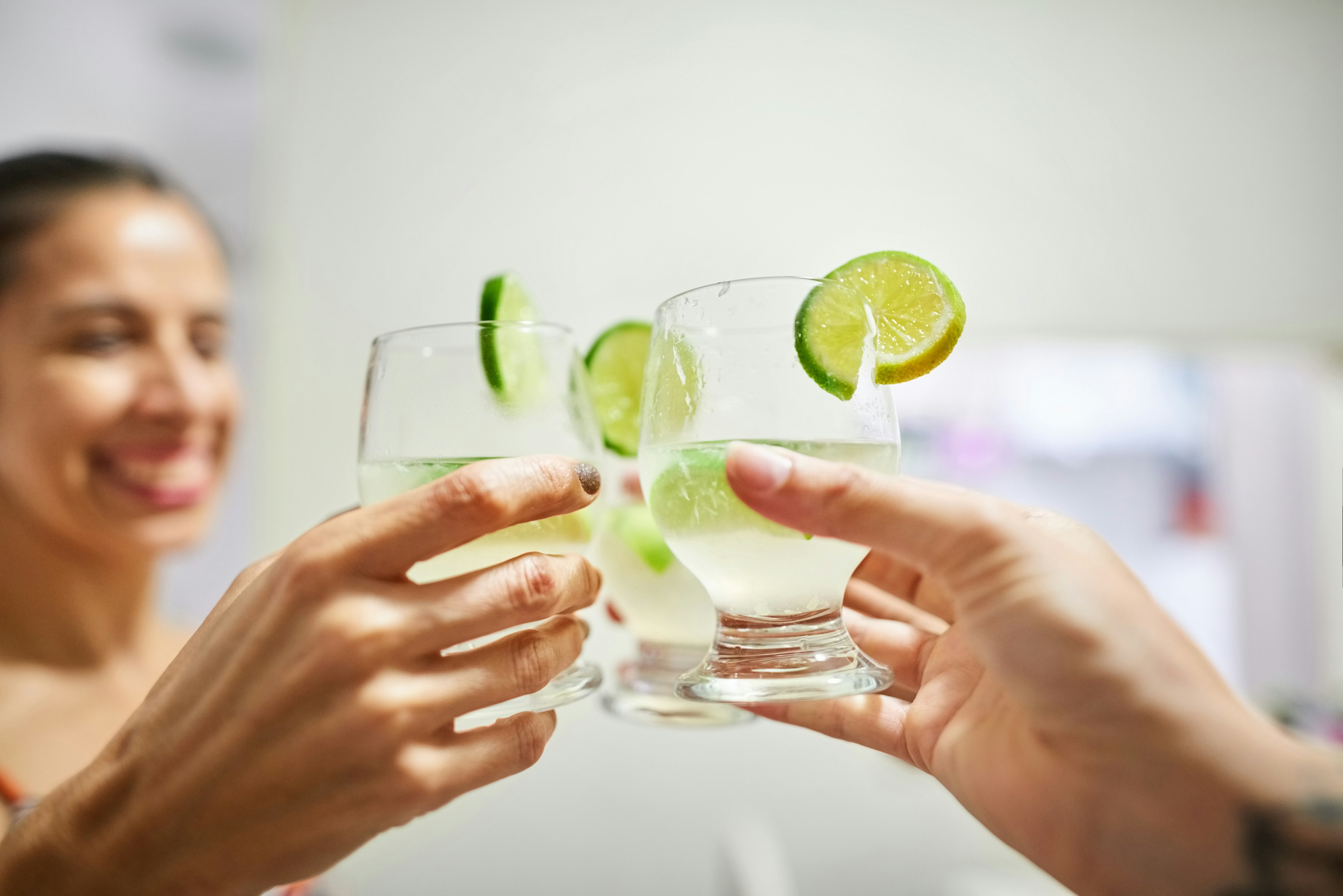 Two women toast glasses of caipirinha