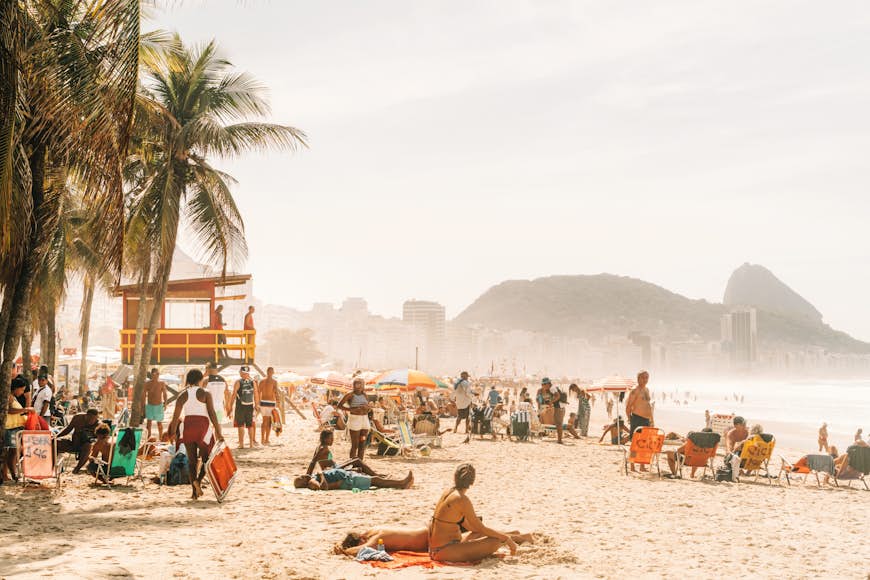 People relaxing and sunbathing at the famous Copacabana beach in Rio de Janeiro, Brazil