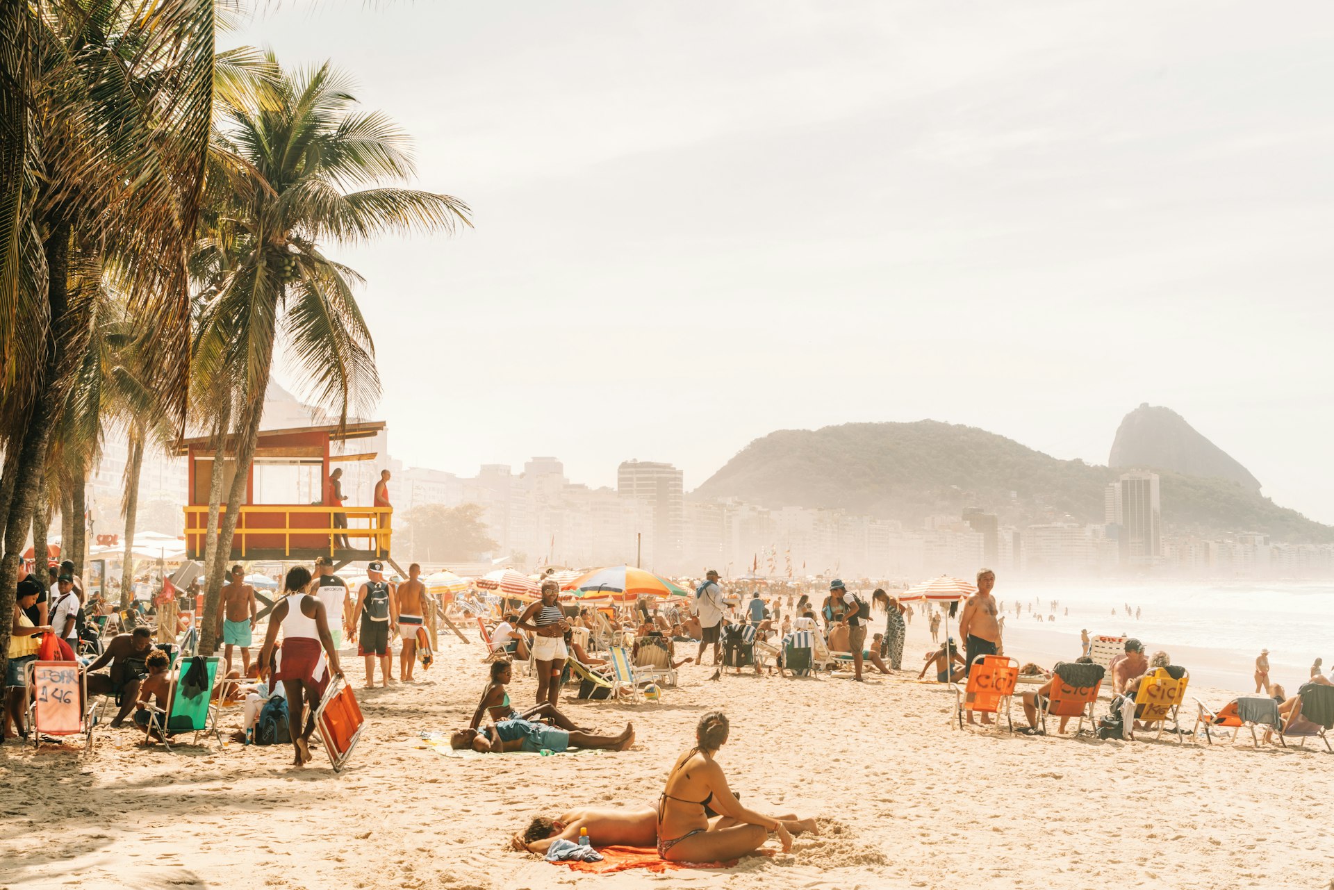 People relaxing and sunbathing at the famous Copacabana beach in Rio de Janeiro, Brazil