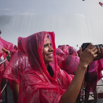 A young woman photographing on a tourist boat