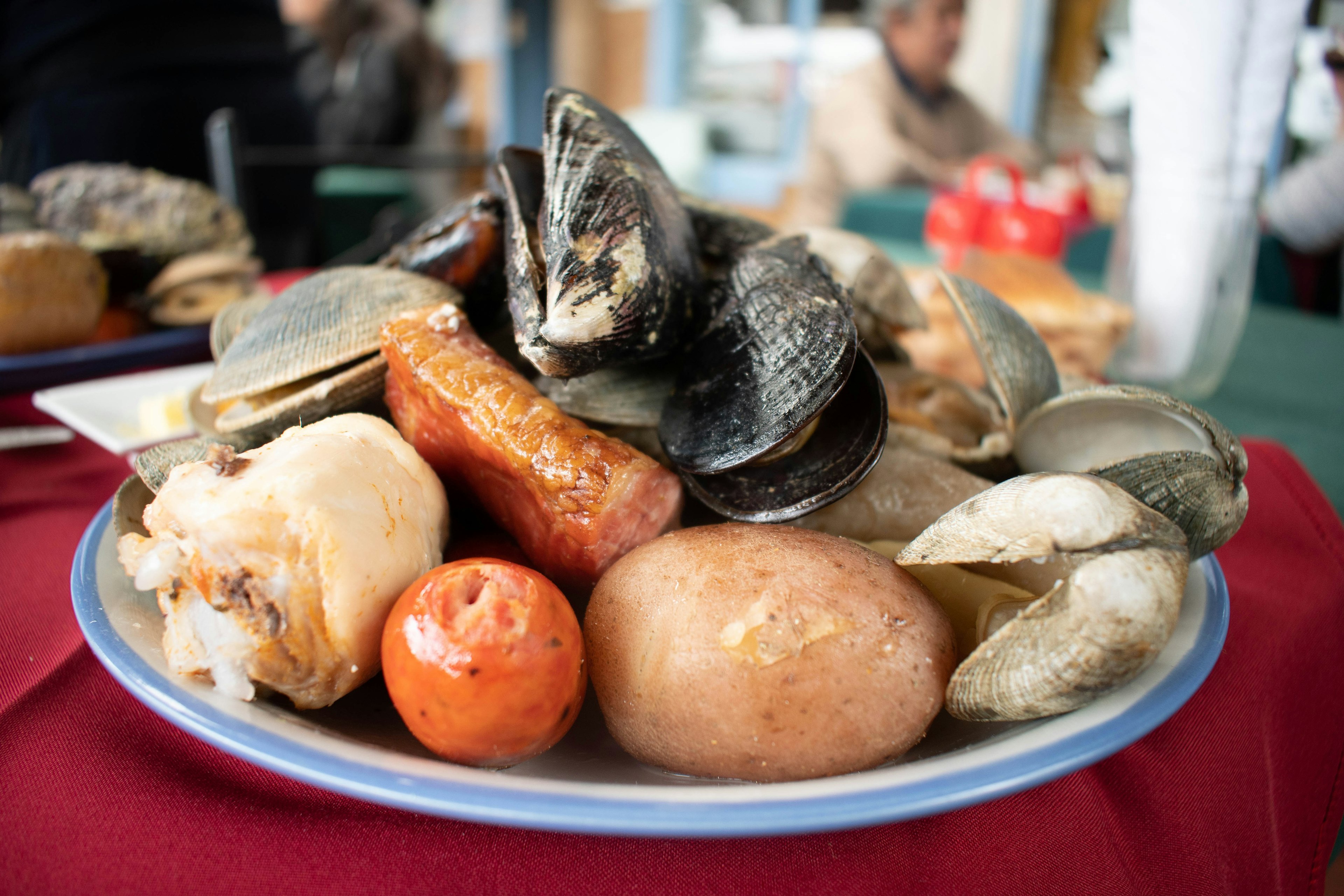 Plate of curanto, a typical dish from Chiloe in Chile, sitting on a table at a restaurant