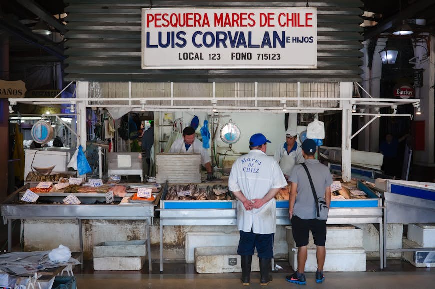 Seafood vendor selling fish at the Mercado Central fish market in Santiago de Chile, Chile