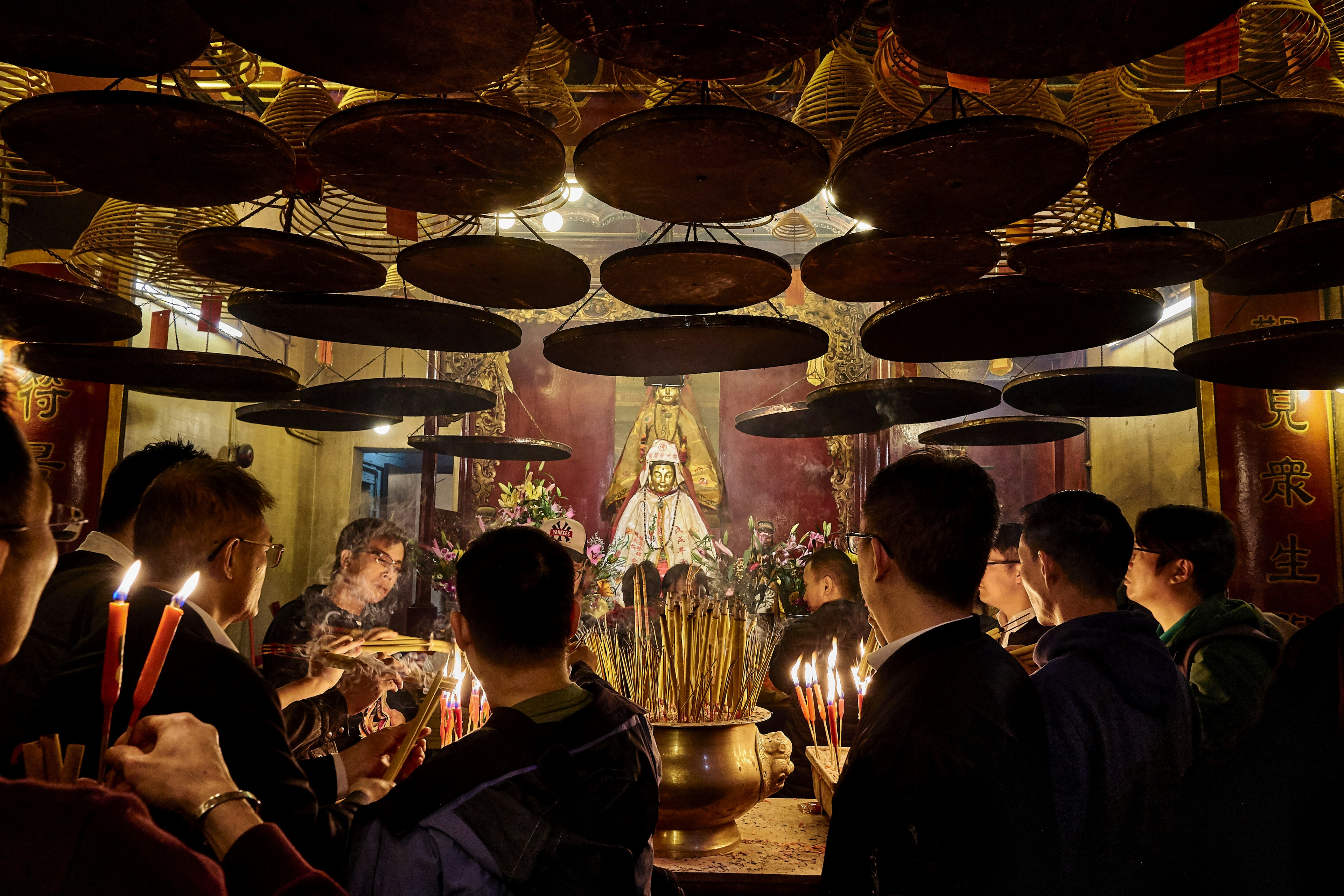 Devotees, some with candles, stand in front of the shrine at the Man Mo Temple in Hong Kong