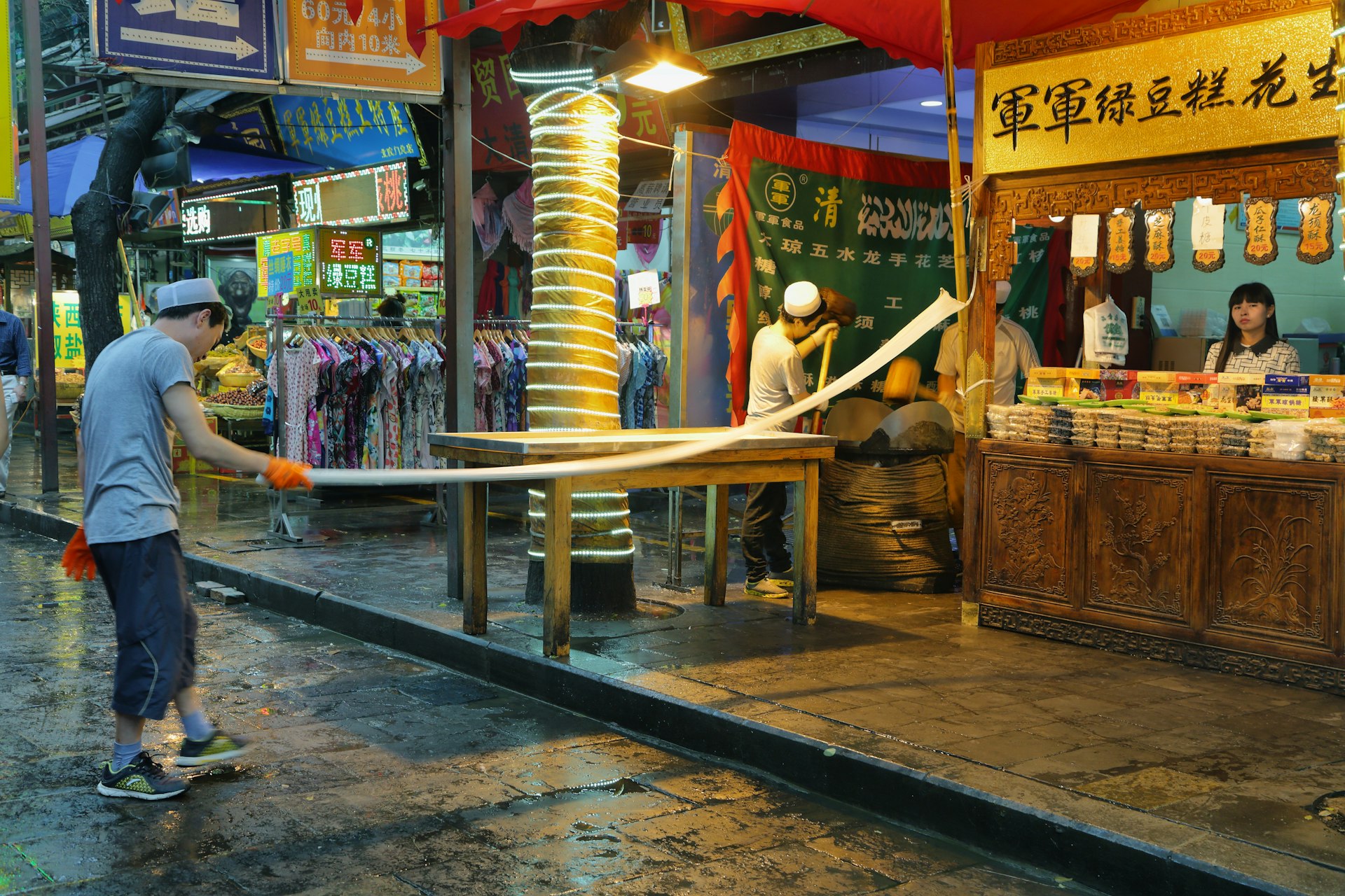 Unidentified man making handmade noodles in a food store on a rainy day in the Muslim Quarter of Xian, China.