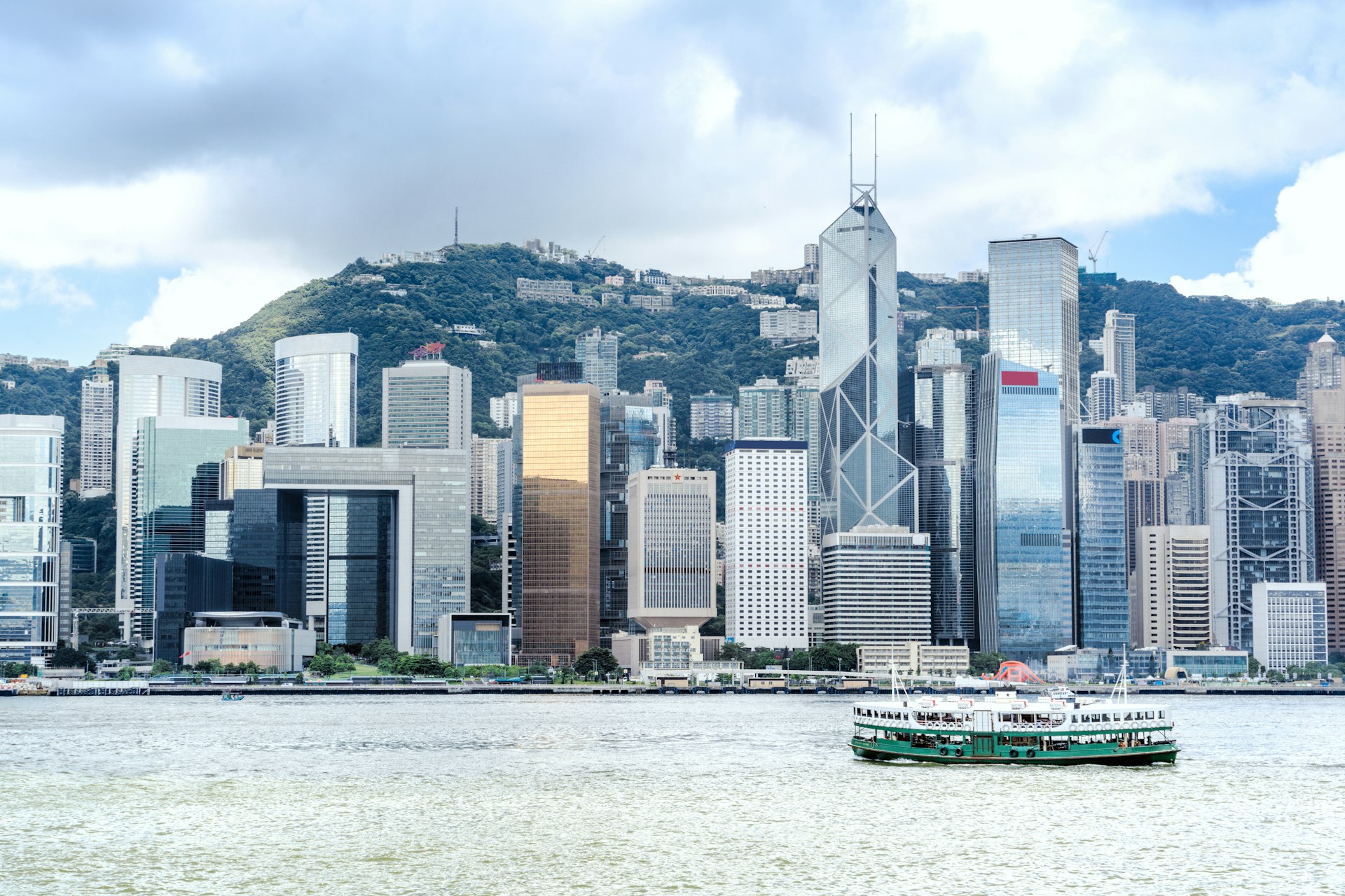 A Star Ferry crosses the waters of Victoria Harbour in Hong Kong with skyscrapers in the background 