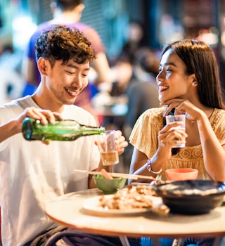 Asian couple enjoying street food in Hong Kong