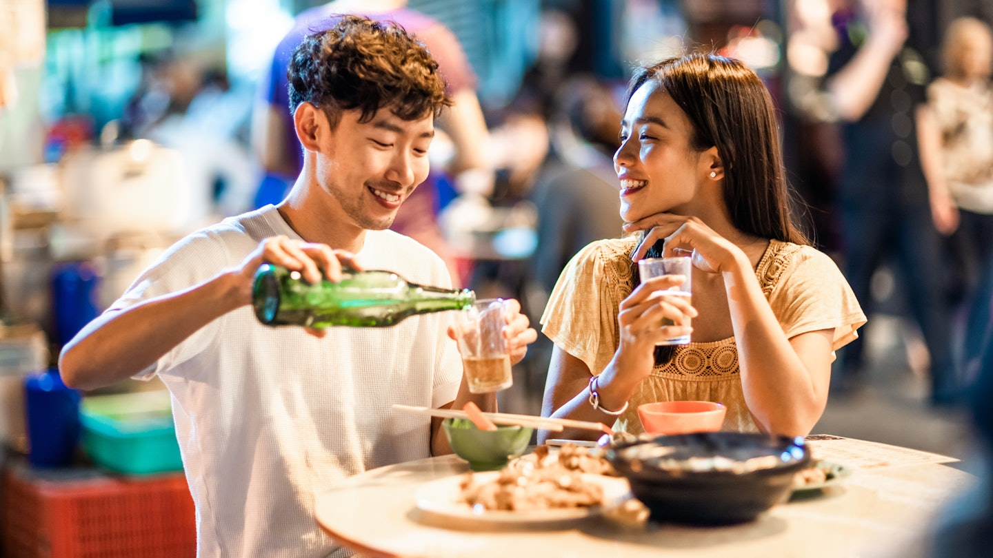 Asian couple enjoying street food in Hong Kong