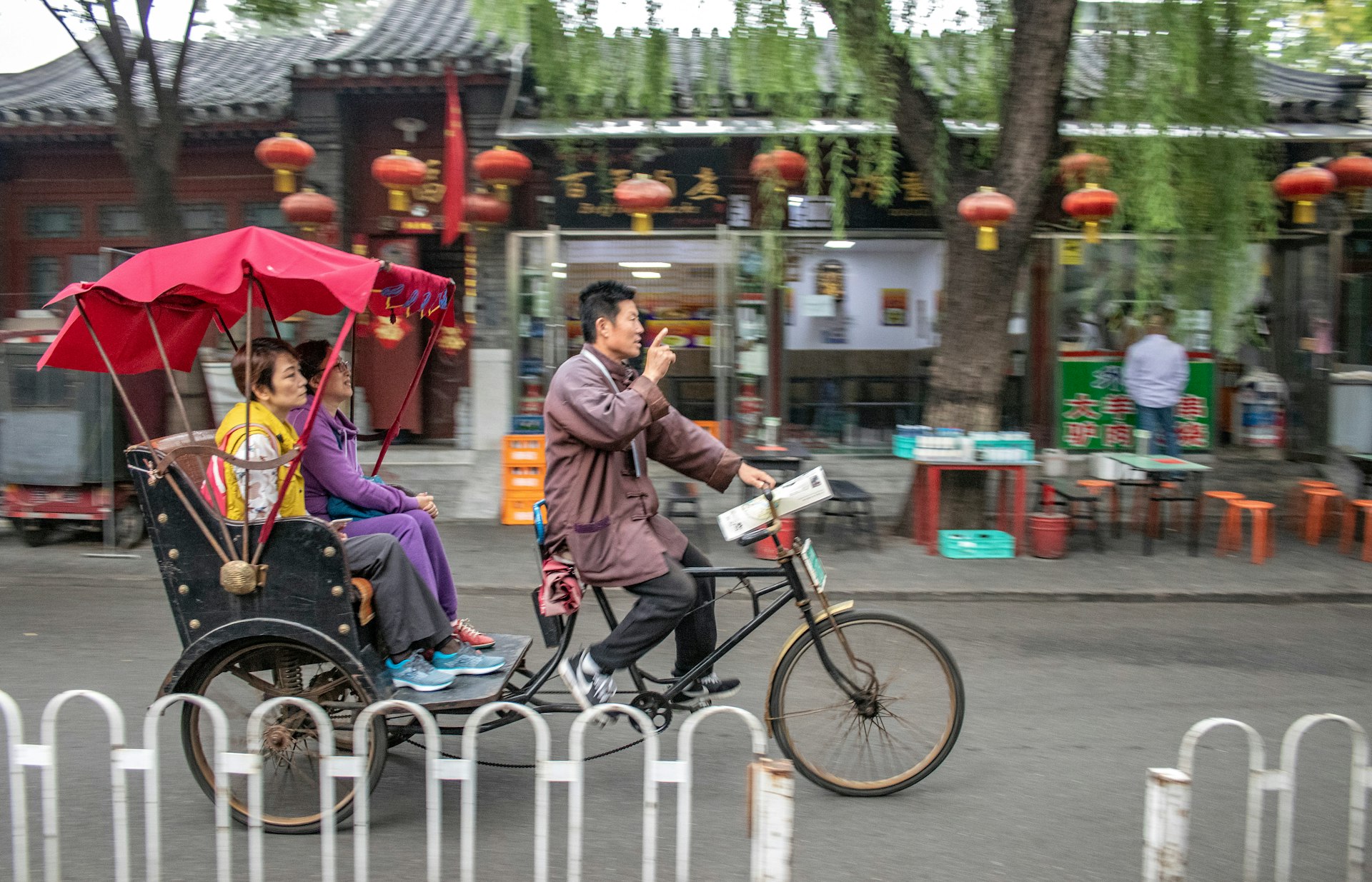 A rickshaw drives tourists around a Beijing hutong district during the Chinese Golden Week