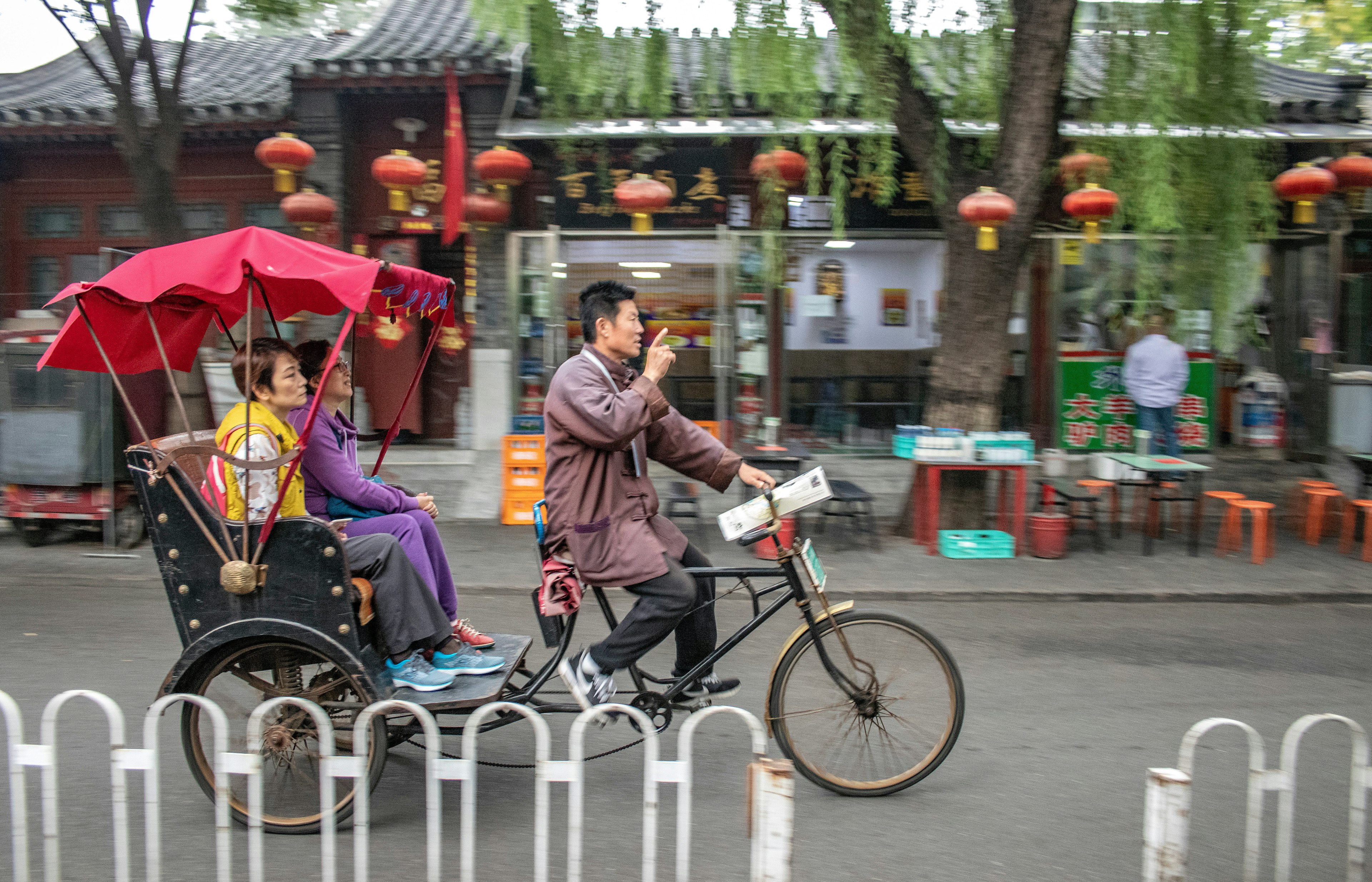 A rickshaw drives tourists around a Beijing hutong district during the Chinese Golden Week