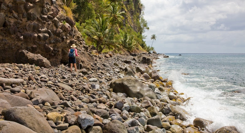 CP7J5A A female walker negotiates the slippery rocky coastal section of Segment 13 of the Waitukubuli National Trail in Dominica