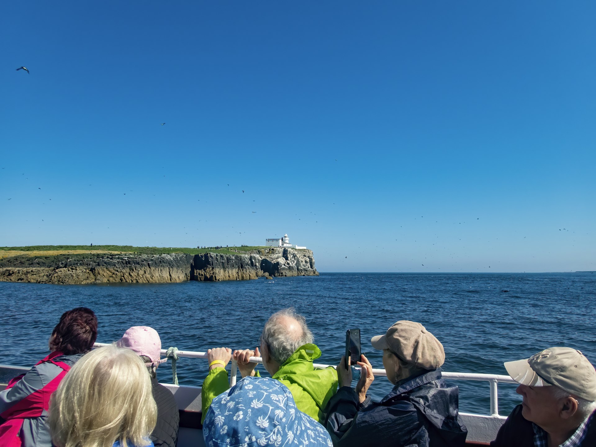 Families and tourists riding the ferry to the Farne Islands from Seahouses harbor, on the Northumberland Coast in northeast England, on a bright. sunny summer's day