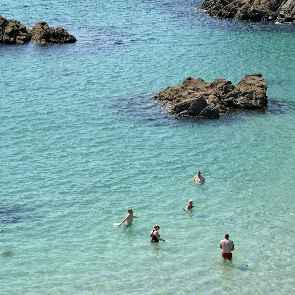 Kynance Cove, Cornwall - 20 July 2021: swiming in Kynance Cove; Shutterstock ID 2153041741; your: Sloane Tucker; gl: 65050; netsuite: Online Editorial; full: England Beaches Article