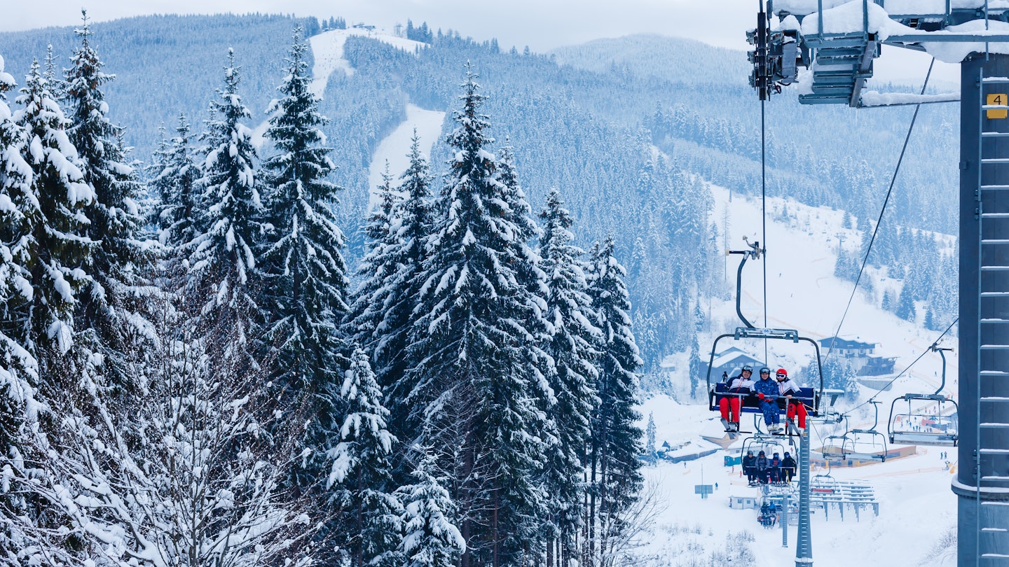 Ski lift - happy skiers in ski resort