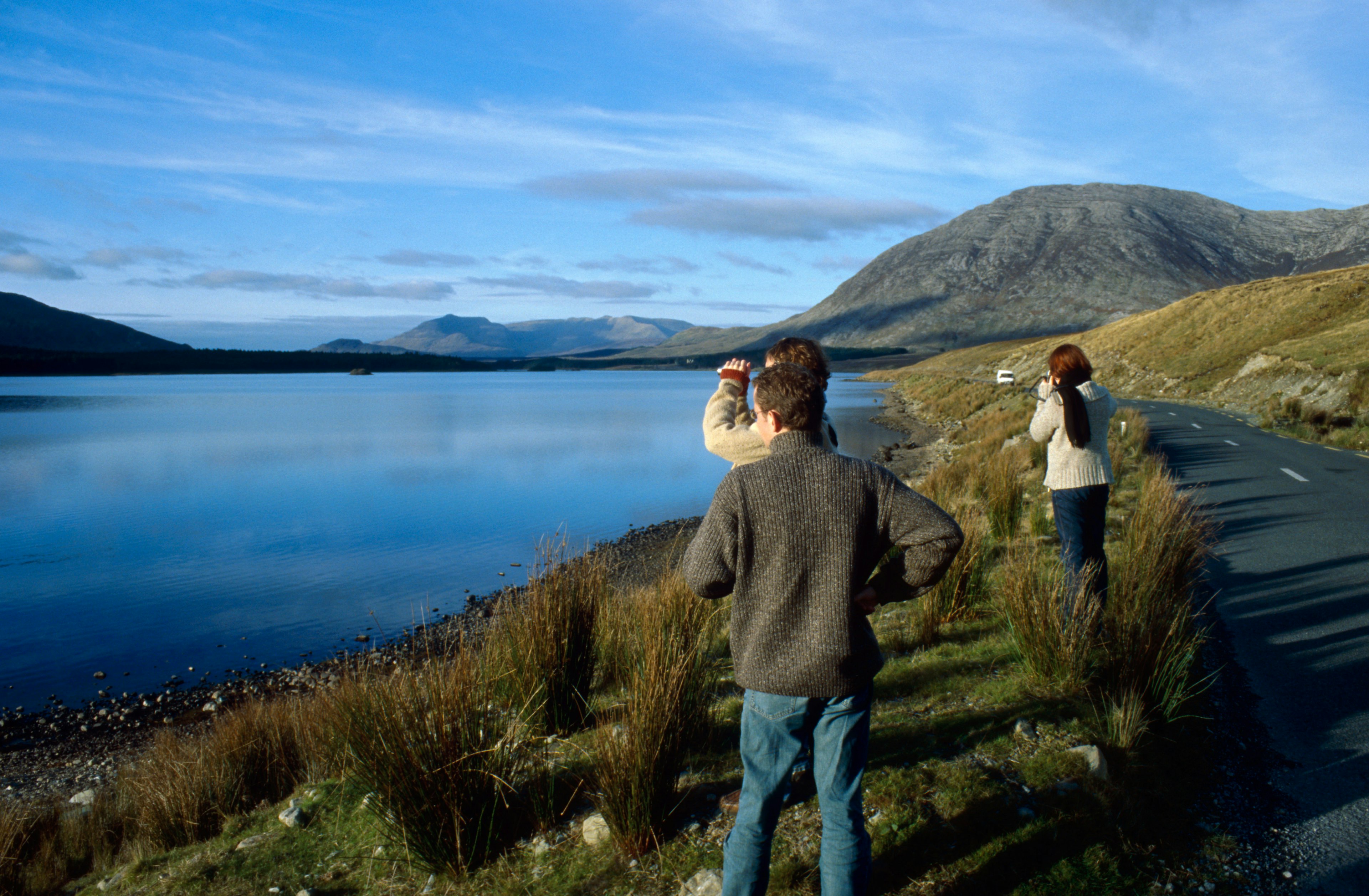 Small group of people is standing on the road side to gaze at the astonishing scenery of Connemara in Ireland.