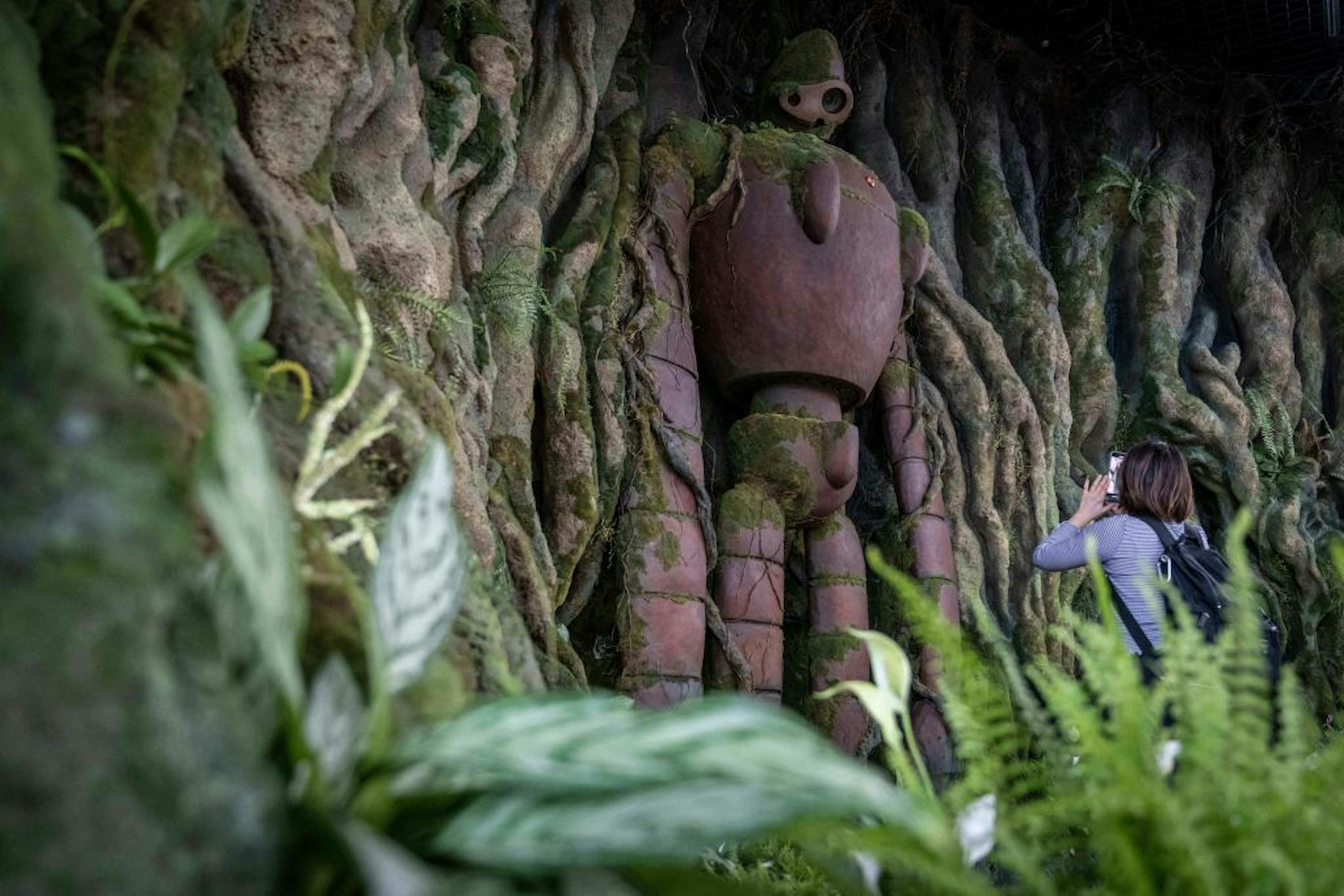 A member of the media takes a photograph of an exhibit at Ghibli's Grand Warehouse during a media tour of the new Ghibli Park in Nagakute