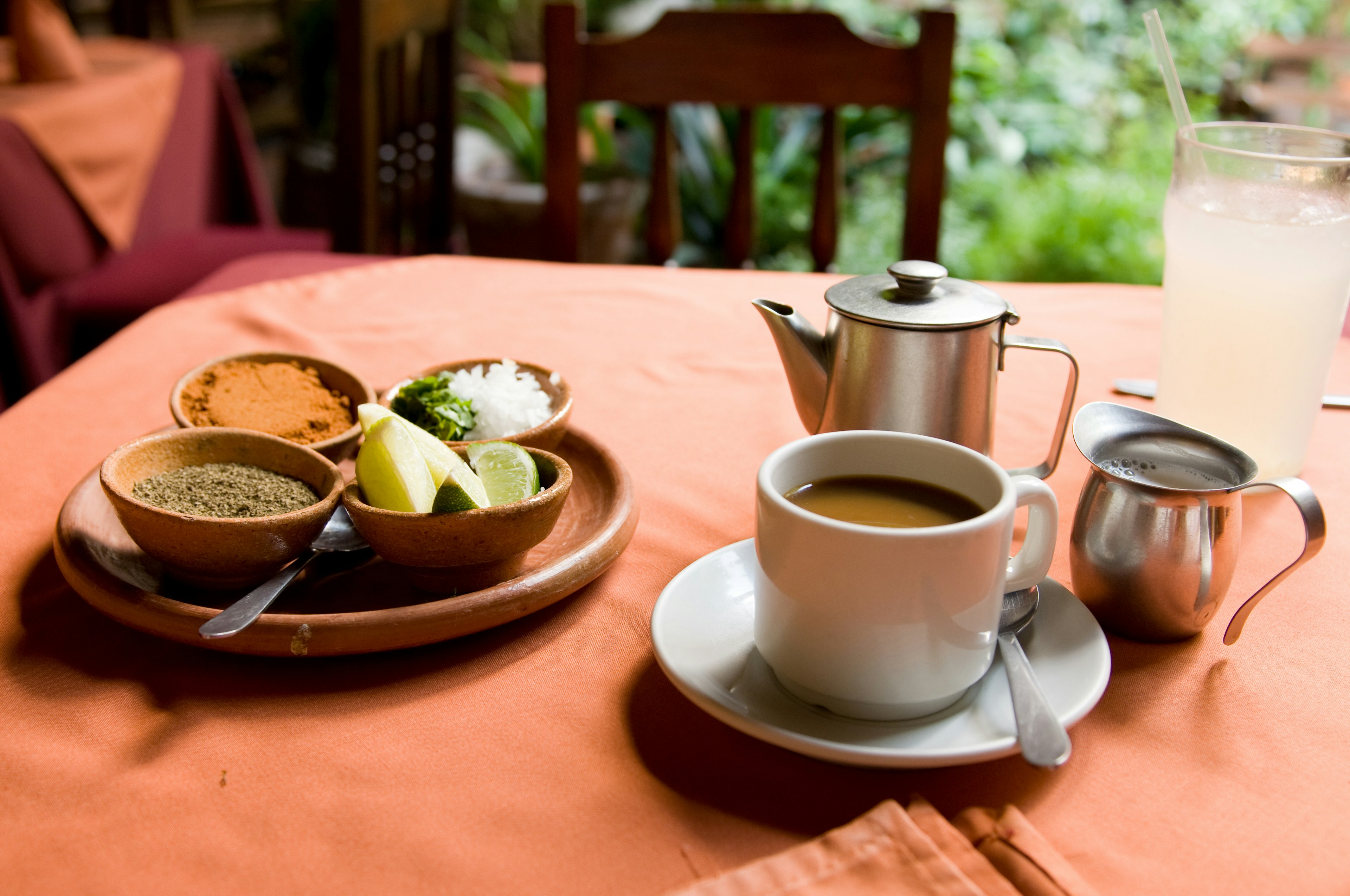 A table full of Guatemalan essentials: coffee and spices (chili powder, onion, cilantro, and lime