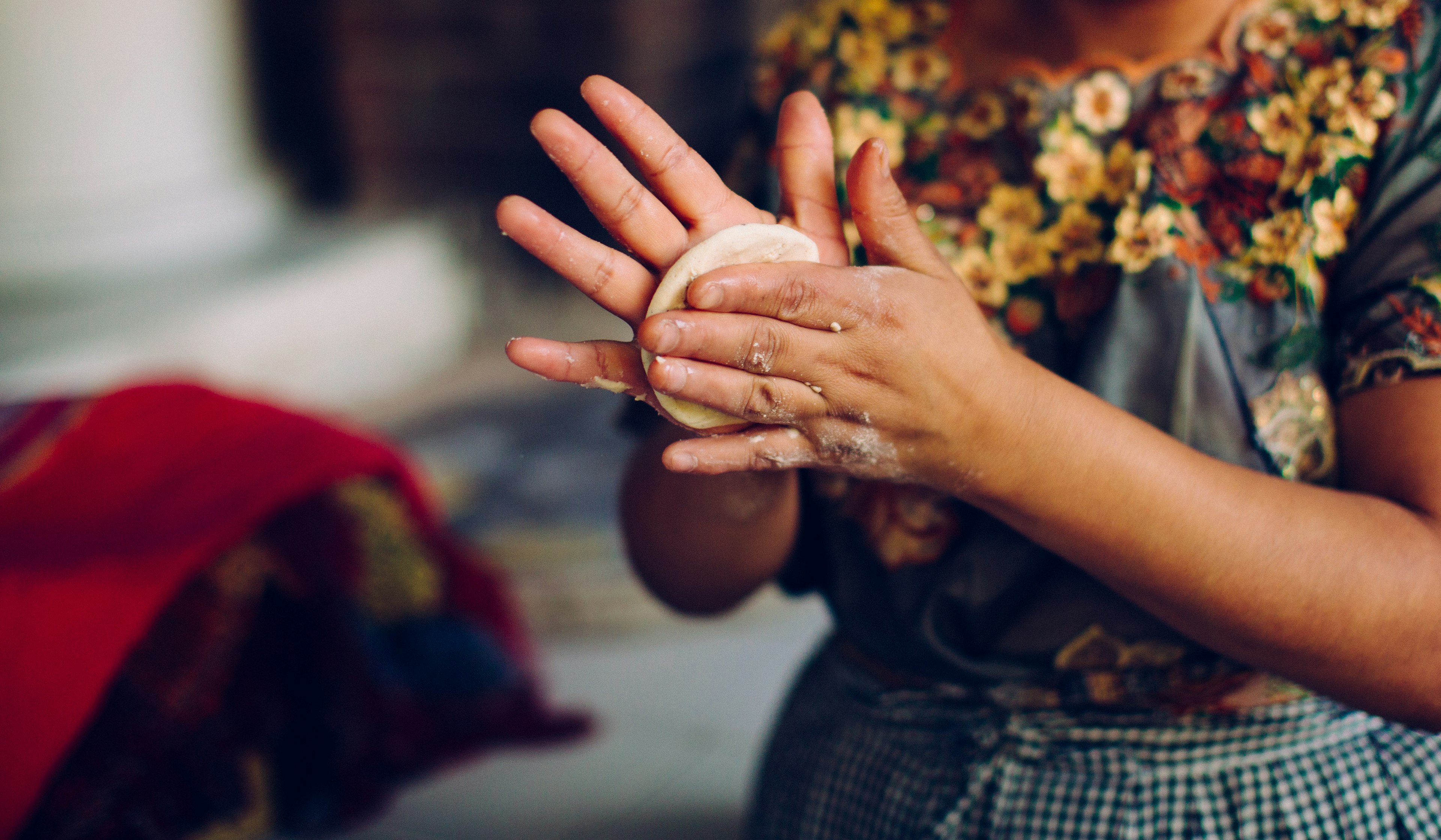 detail of a woman making tortillas in antigua, guatemala