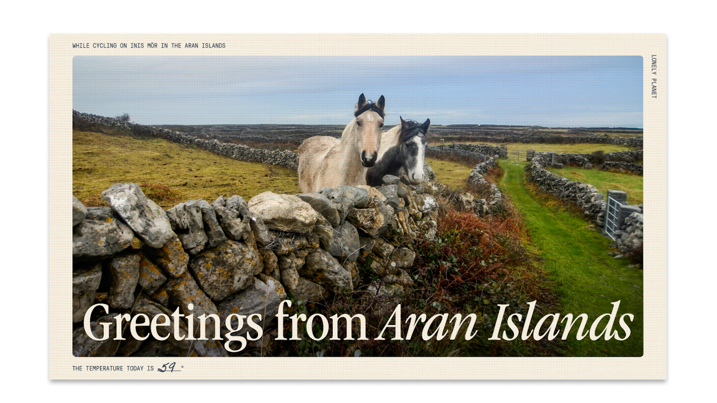 Curious horses look out from behind a stone fence on Inis Mór.