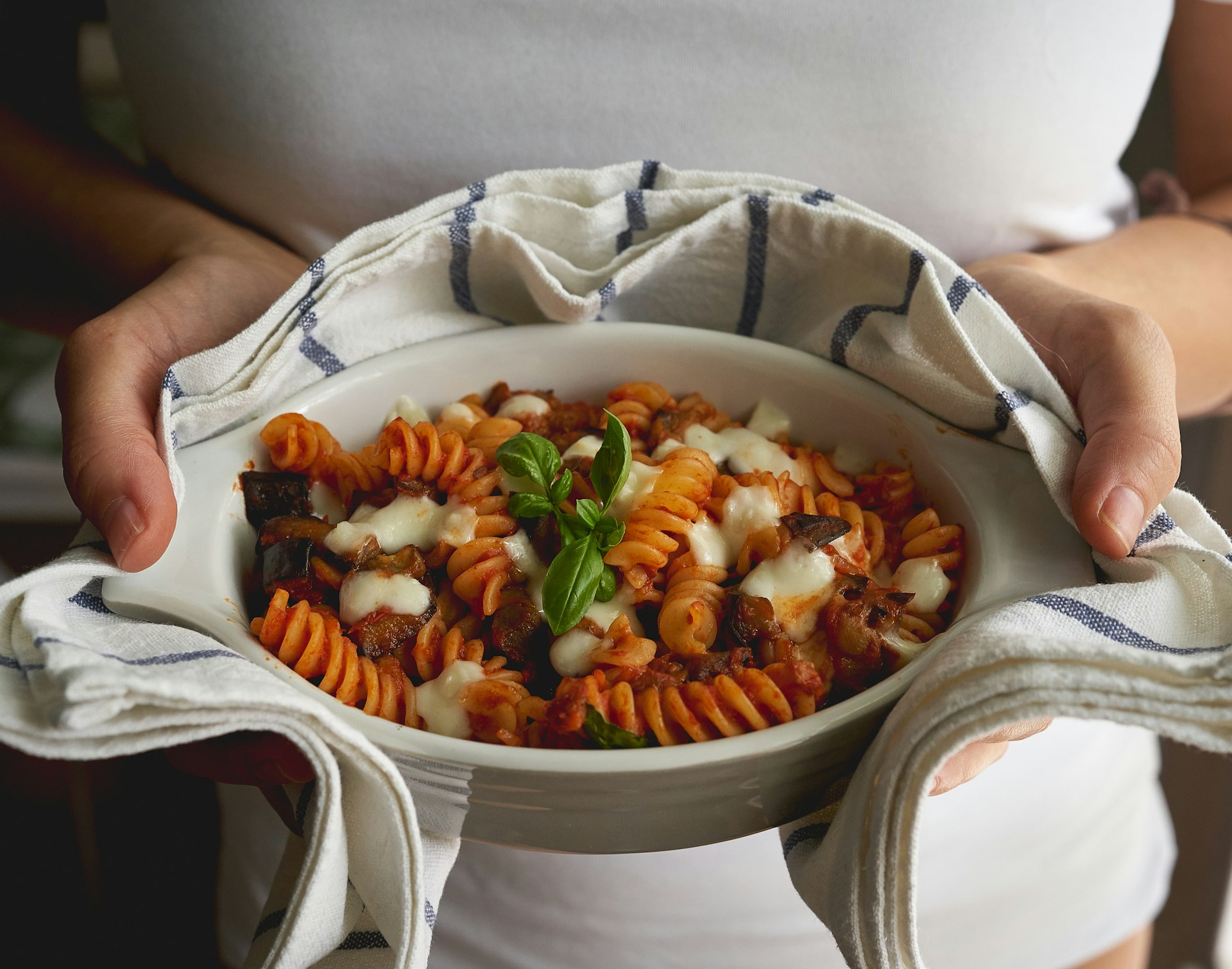 A homemade dish of fusilli pasta "alla Norma", a typical Sicilian dish made with fried aubergines, mozzarella or ricotta cheese, tomato sauce and basil. Mediterranean diet.