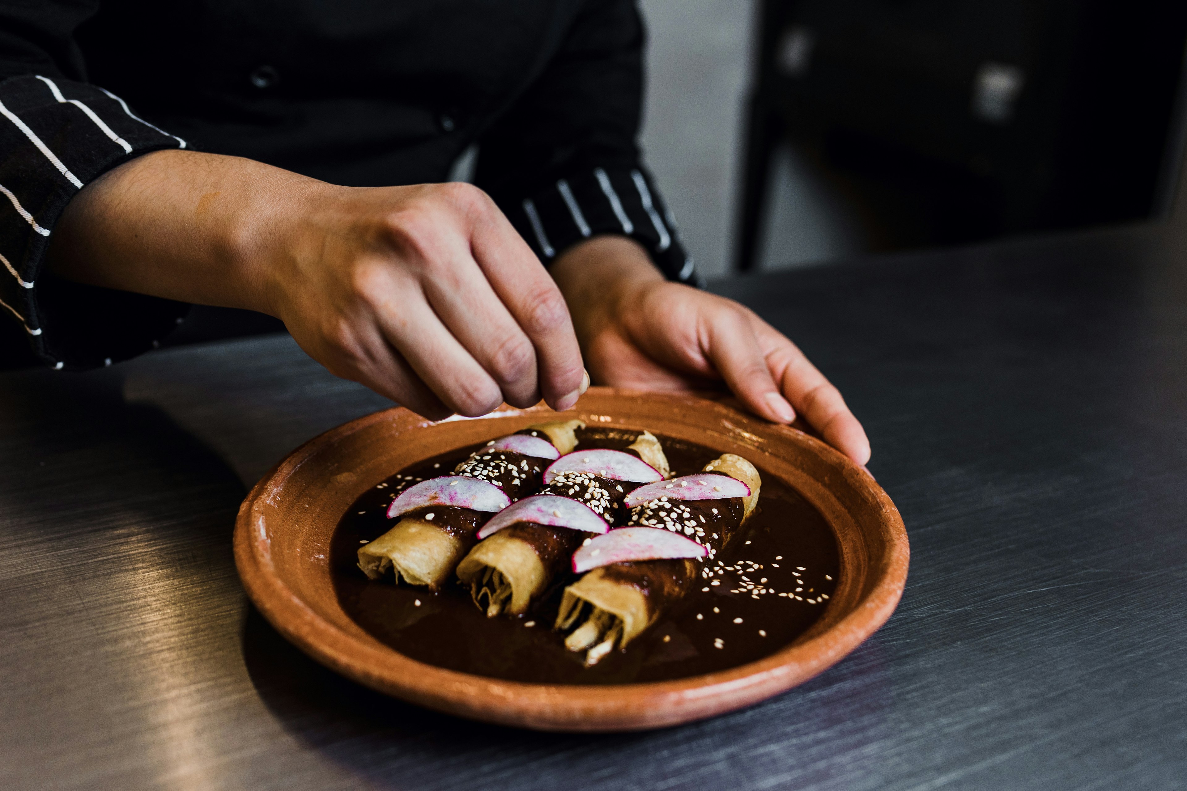 Chef cooking traditional Mexican mole in a restaurant kitchen