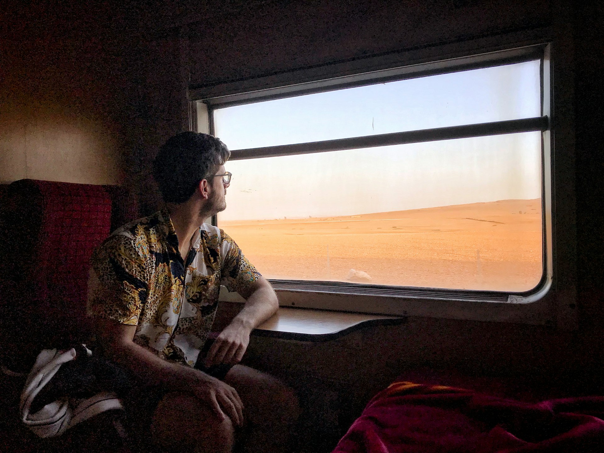 Young man looking through window while on a train in Morocco