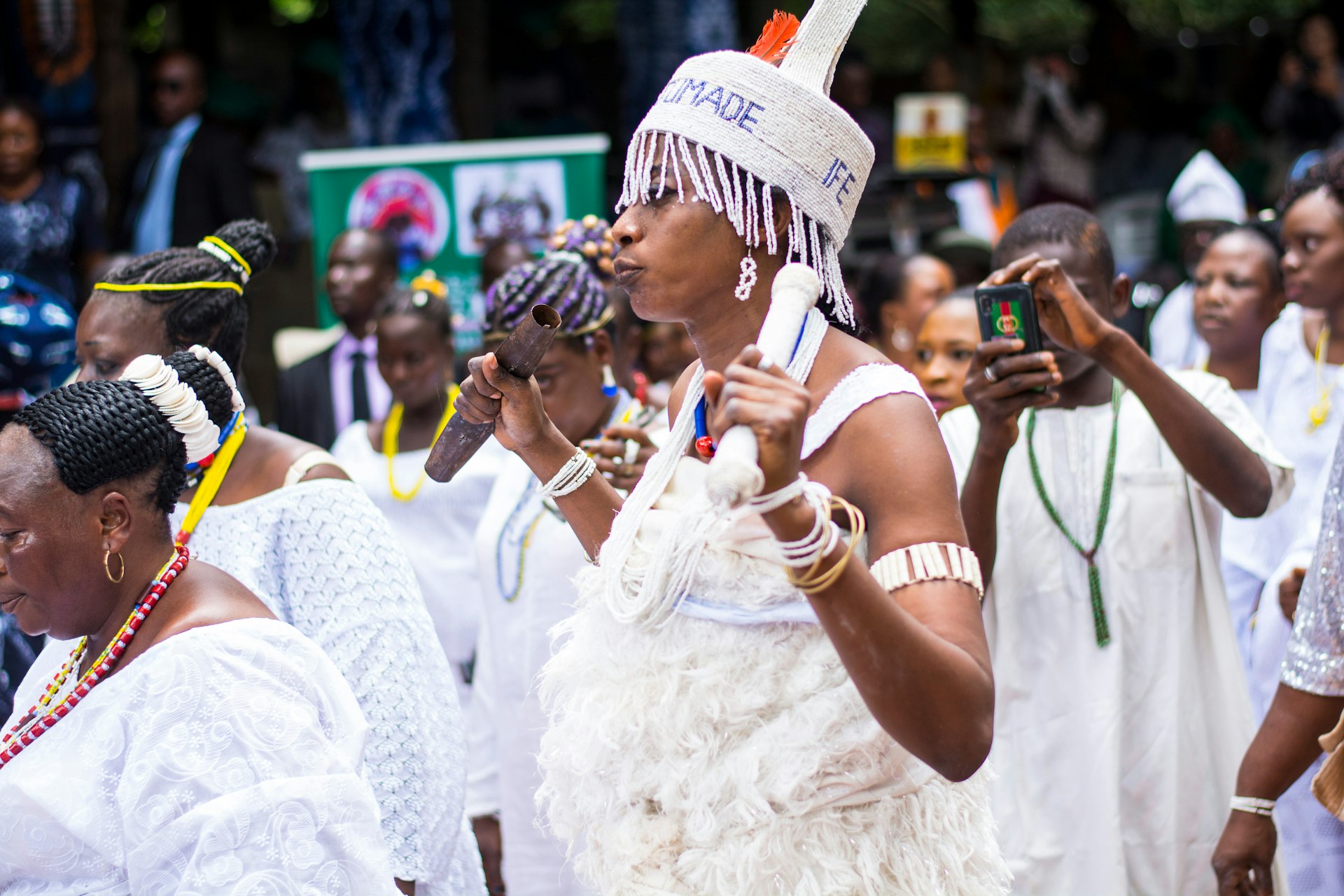 Osun worshippers, dressed all in white and holding instruments, at Osun Osogbo festival Nigeria