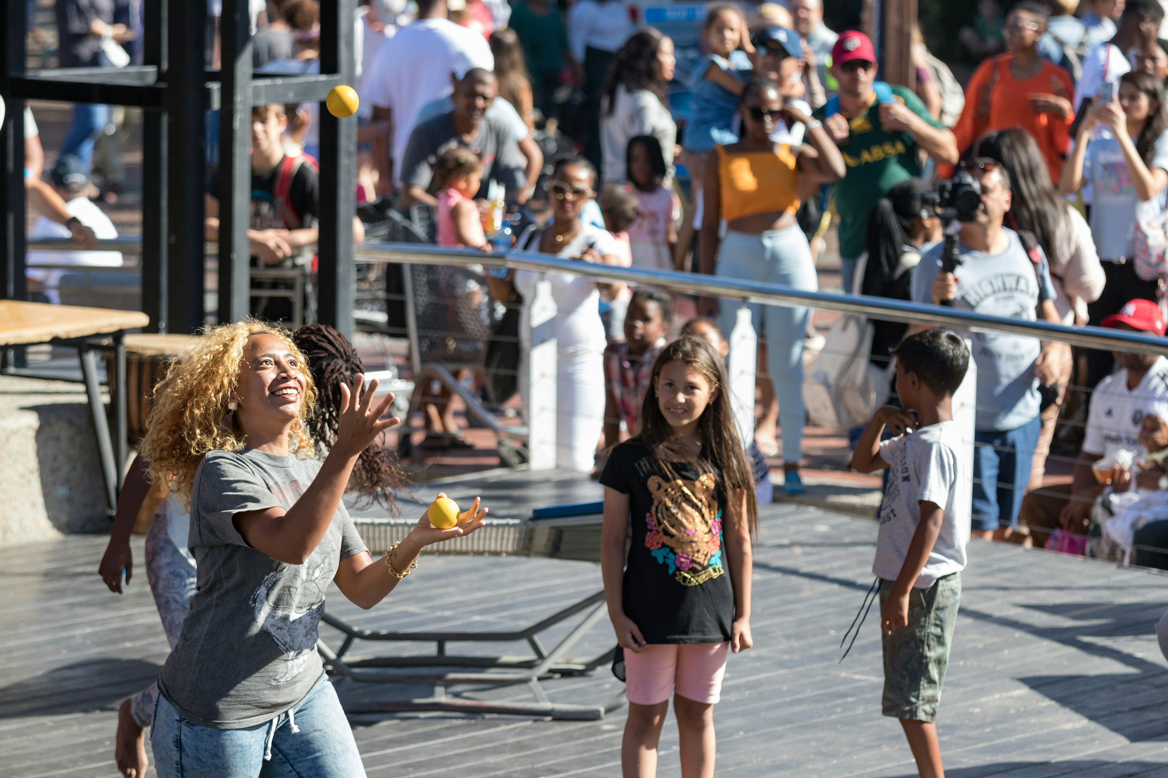 Crowds of people look on at an entertaining juggling balls