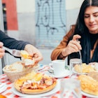 Friends enjoy a meal and coffee at an outdoors cafe in Madrid.