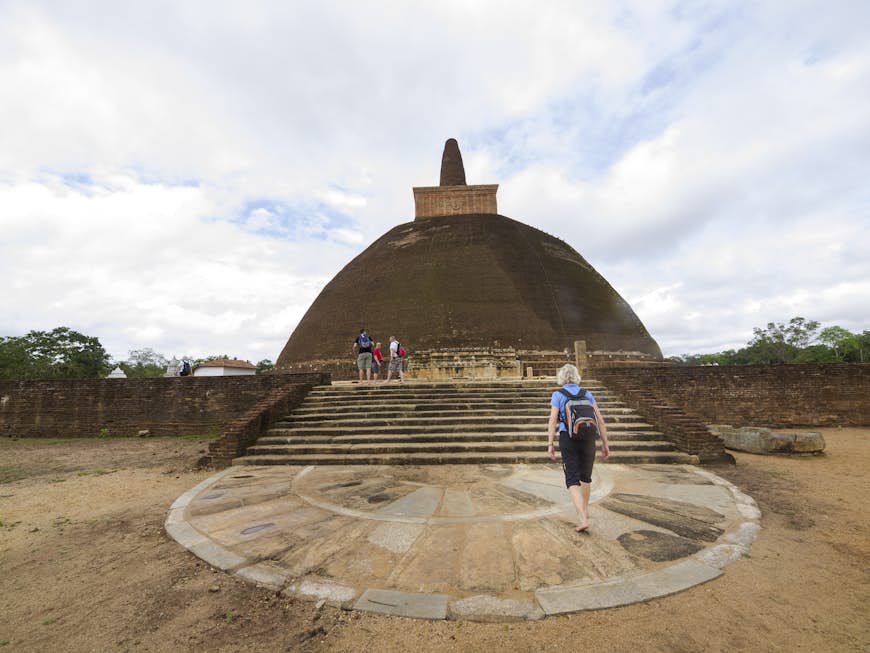 Tourists walking at the site of the ancient stupa Abhayagiri Dagaba, at Abhayagiri Vihara, a major Buddhist monastery site in Anuradhapura.