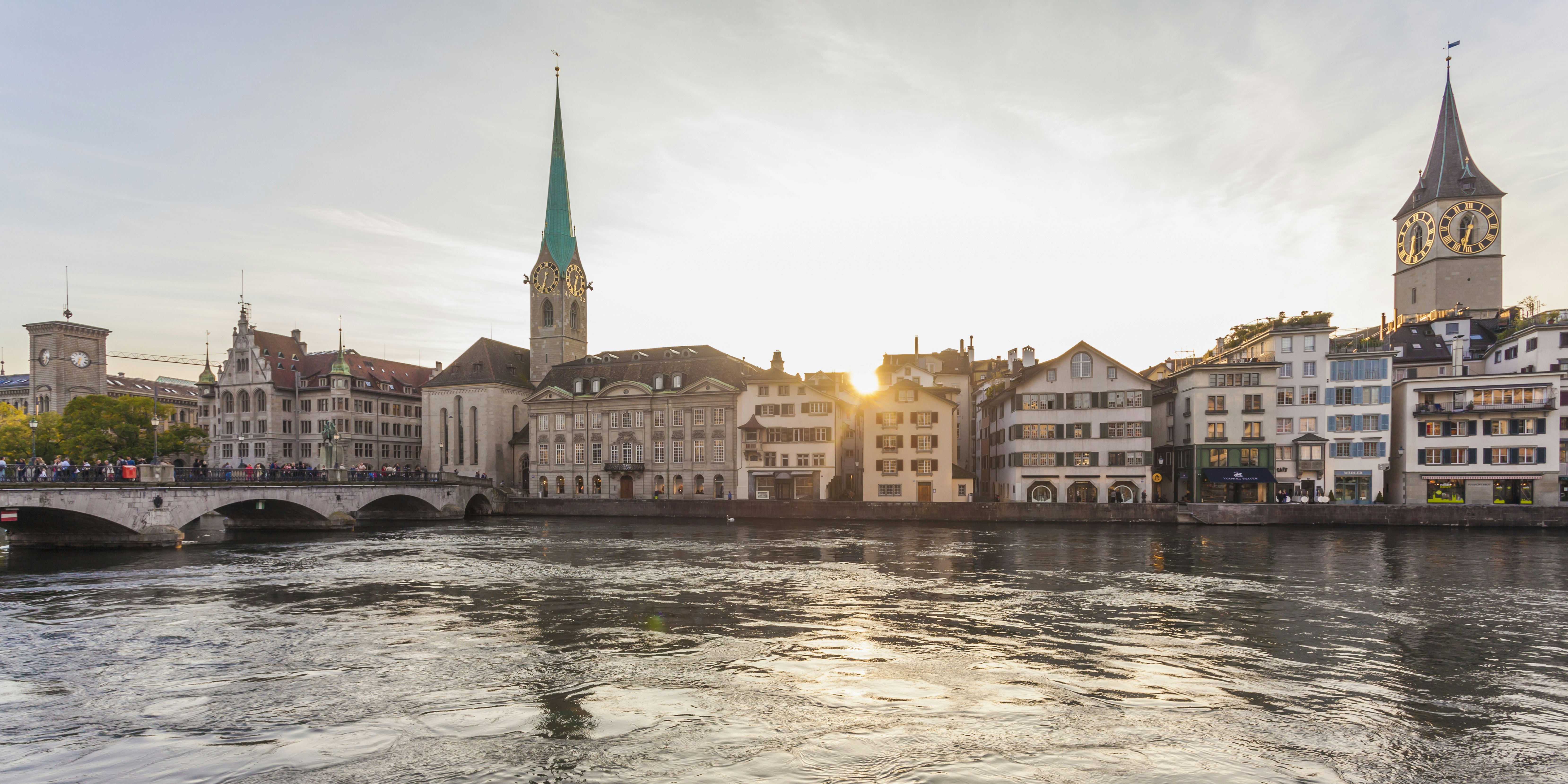 Church of Fraumünster and the Zürich skyline in the evening behind the Limmat River