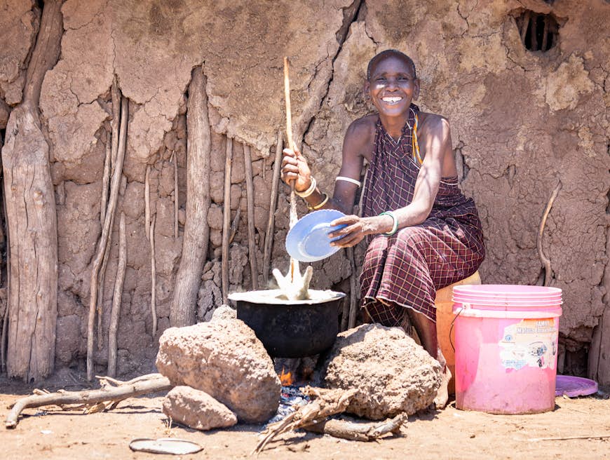 Datoga Woman cooking ugali outside her house