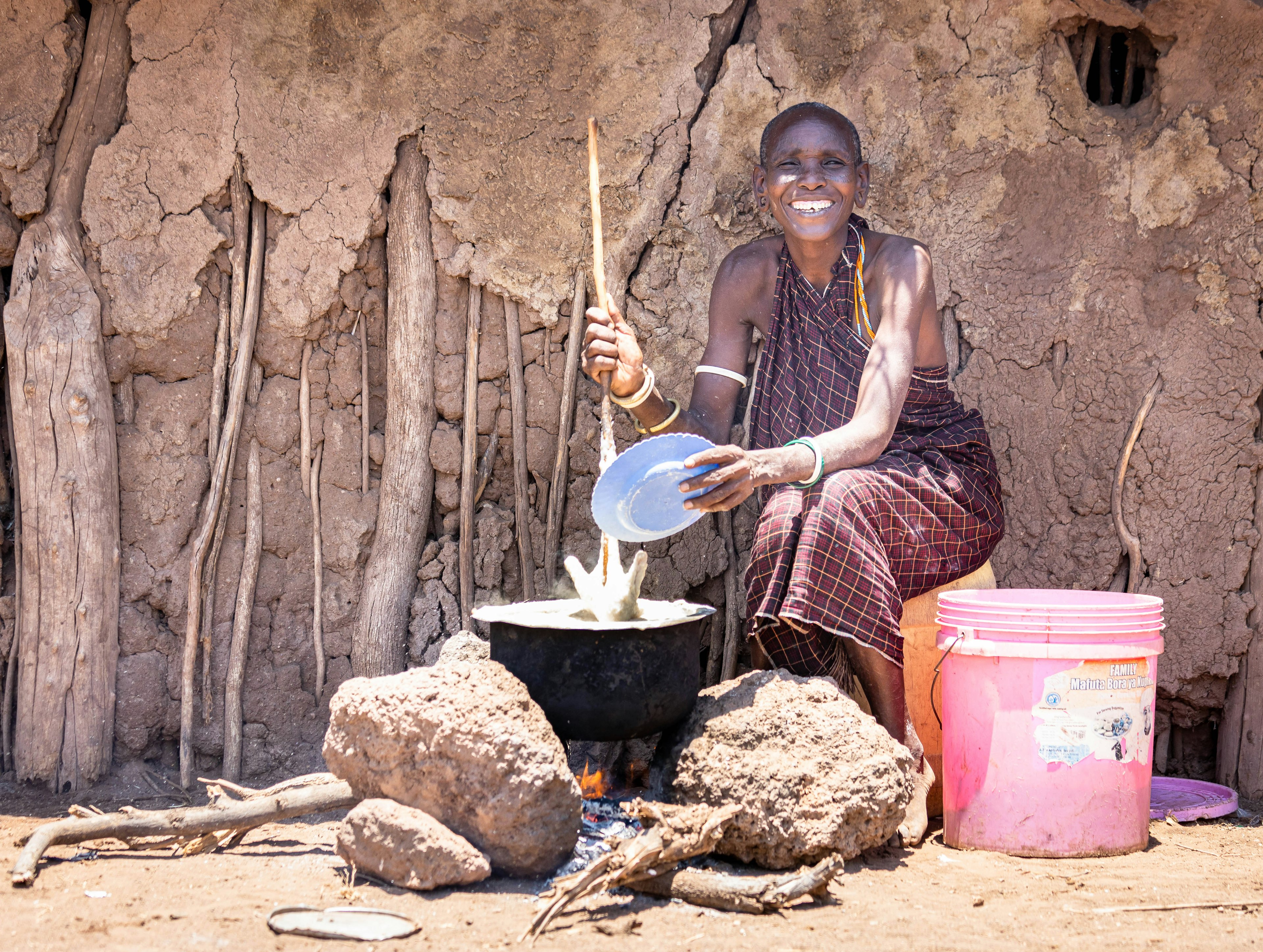 Datoga Woman cooking ugali outside her house