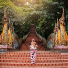 Young woman walking up the stairs of the temple, Doi Suthep in Chiang Mai, Thailand. Huge stairs of Doi Suthep temple in Chiang Mai, Thailand