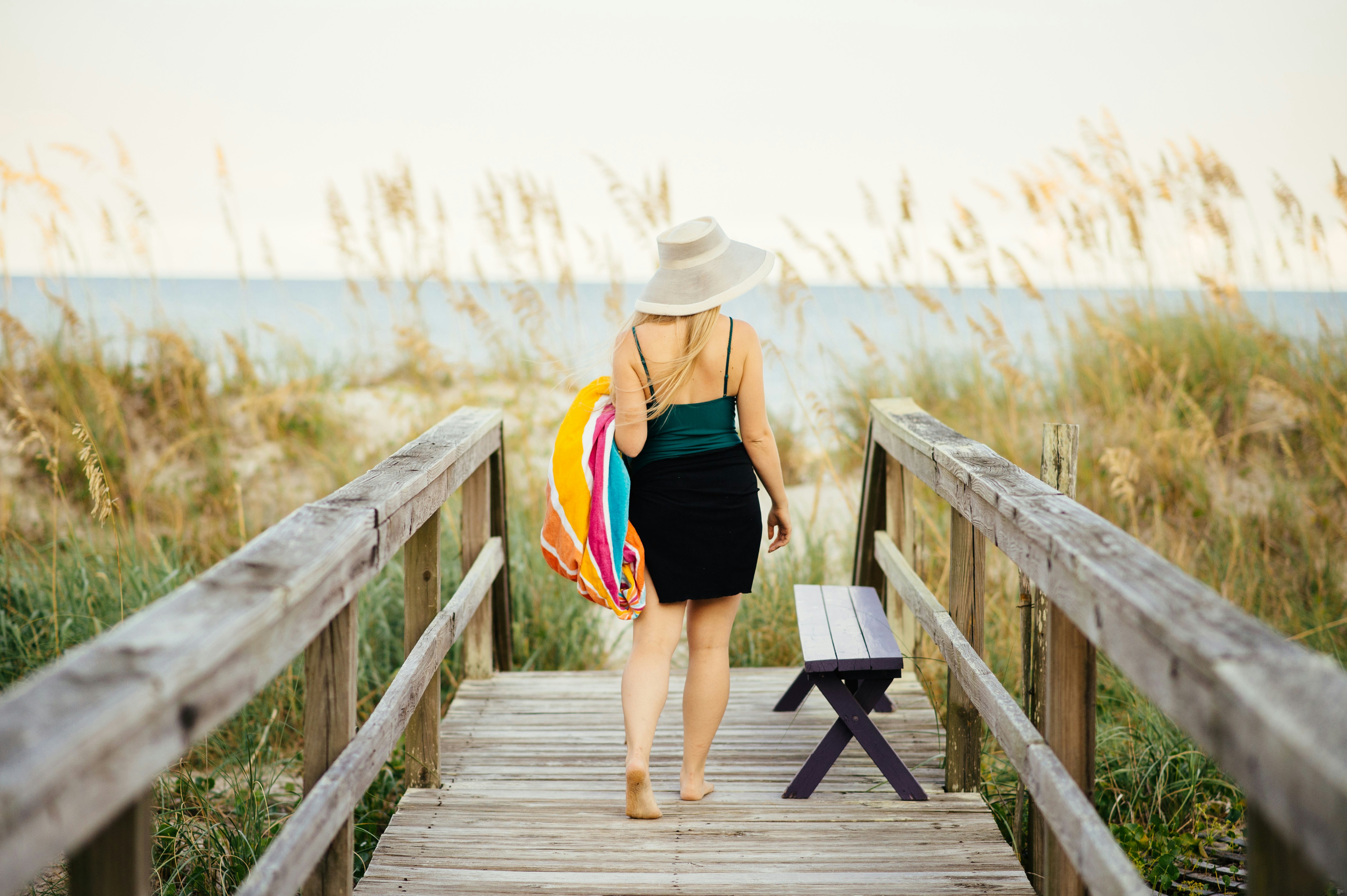 Young woman walking on boardwalk to Carolina Beach