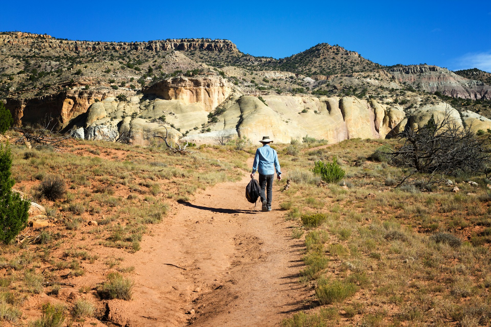 Senior man hiking on a red trail at Ghost Ranch in New Mexico