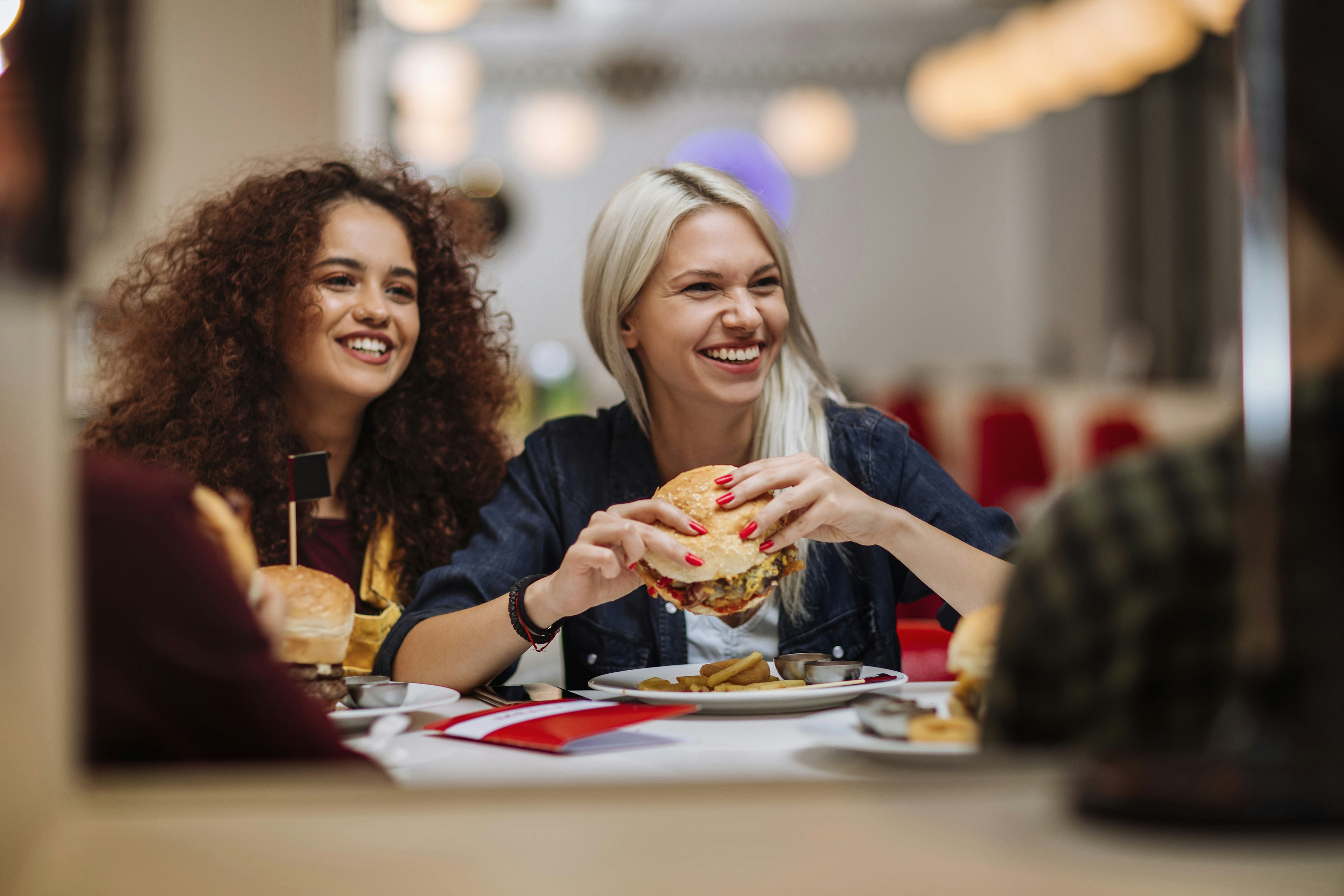 Two women eat burgers at a diner in the USA