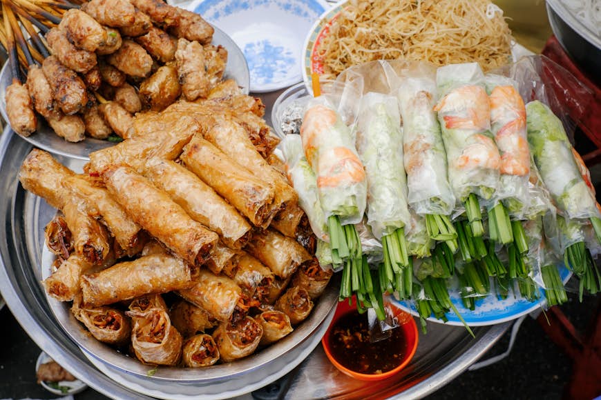 Three piles of nem ran ha noi and goi cuon, types of stuffed spring rolls on sale in Vietnam