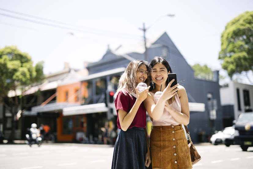 Two slightly dorky hipsters enjoying a day walk in the sunny Surry Hills, Sydney, Australia. The girls are happy to spend some time together eating ice cream and drinking cold drinks.